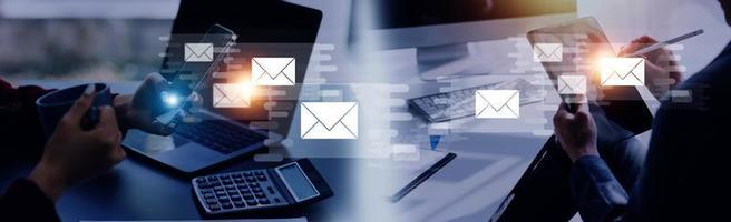 Businessman hands using Laptop typing on keyboard and surfing the internet on office table with email icon, email marketing concept, send e-mail or news letter, online working internet network. photo