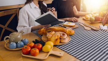 joven mujer comiendo Pizza y riendo mientras sentado con su amigos en un restaurante. grupo de amigos disfrutando mientras teniendo comida y bebidas a cafetería. foto