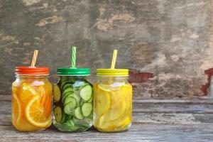 Different drinks of fruits and vegetables on old wooden background. photo