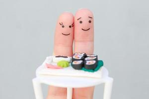 dedos Arte de contento Pareja. hombre y mujer comer Sushi en cafetería. foto