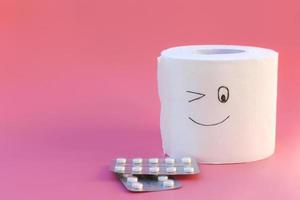 Toilet paper and pills. Concept of hemorrhoid treatment. photo