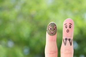 Fingers art of couple. Husband saw his wife with clay face mask and was afraid. photo