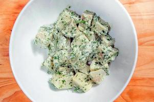 Potato salad with mustard seeds and white filling in rustic style photo