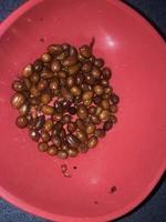 fried peanuts in a red plastic bowl. photo