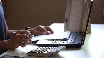 Side view of male hand using a calculator to calculate the first quarter of the year,Advertising shooting concept video