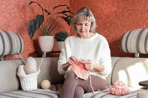 Happy and relaxed female people enjoying time indoor on the sofa. Knit job photo