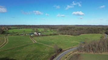 Antenne Aussicht von ein Drohne von ein Wald und Ackerland mit klein Land Straßen und Bauernhöfe im zwischen. video