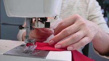 costureira às trabalhos em uma de costura máquina. de costura roupas a partir de tecido video