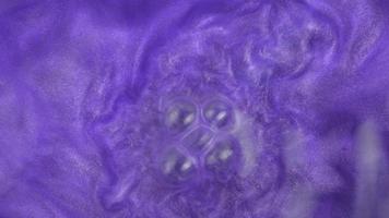 Abstract blurred shining background with sequins. The texture of purple of mother-of-pearl water with bubbles. Bath salts video