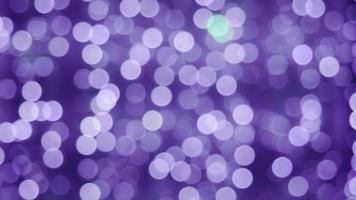 The color of 2022 is Very Peri. Lights festive background. Abstract bright background blurred bokeh, banner video