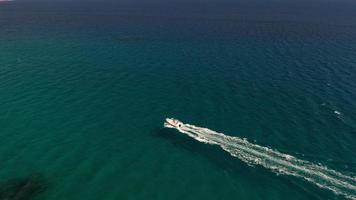 Aerial view - drone follows speed boat on sea video