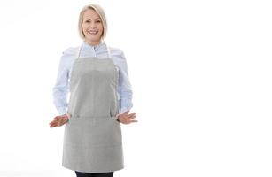 Woman in apron. Confident beautyful woman in apron keeping arms crossed and smiling while standing against white background photo