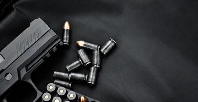 automático negro 9 mm pistola y balas en negro cuero fondo, selectivo y suave enfocar, Copiar espacio. foto