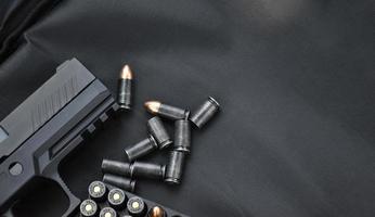 automático negro 9 mm pistola y balas en negro cuero fondo, selectivo y suave enfocar, Copiar espacio. foto