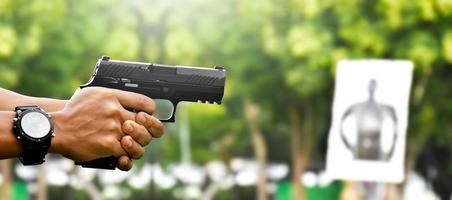 9mm automatic pistol holding in right hand of shooter, concept for security, robbery, gangster, bodyguard around the world. selective focus on pistol. photo