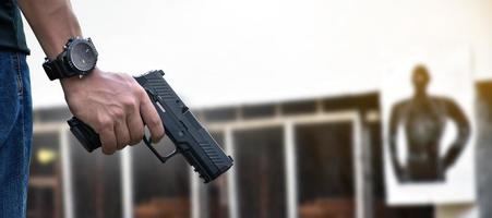 Pistola automática de 9 mm sujeta en la mano derecha del tirador, concepto de seguridad, robo, gángster, guardaespaldas en todo el mundo. enfoque selectivo en pistola.