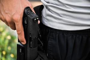 9mm automatic pistol holding in right hand of shooter, concept for security, robbery, gangster, bodyguard around the world. selective focus on pistol. photo