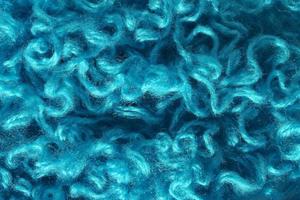 Close-up of colourful merino wool deep blue striped background. Abstract handmade craft knitting yarn textured pattern flatlay. Holiday christmas concept. Idea for felting, needlework, hobby. Mock up photo