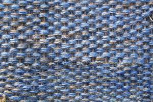 Woven blue wool fabric texture. Hand knitted textile canvas background. Patchwork carpet backdrop. Factory material threads. Abstract design. Close-up, mockup, top view photo