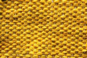 Woven yellow wool fabric texture. Hand knitted textile canvas background. Patchwork carpet backdrop. Factory material threads. Abstract design. Close-up, mockup, top view photo