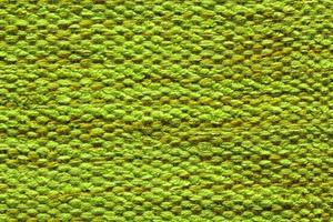 Woven green wool fabric texture. Hand knitted textile canvas background. Patchwork carpet backdrop. Factory material threads. Abstract design. Close-up, mockup, top view photo