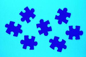 Blue mosaic game details of jigsaw puzzle elements on blue background. Completing task or solving problem concept. World mental health day, autism awareness day. Global communication. Hobby, play photo