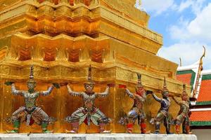 el ramayana gigante estatuas son en pie con grande dorado pagoda antecedentes a wat ph-ra kaew antiguo templo en bangkok, tailandia punto de referencia en centrar de Tailandia y Arte diseño. exterior y estructura. foto