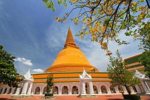 Wat Pra Thom Chedi, This place important Buddhist temple in Thailand and famous tourist travel to destination at Nakhon Pathom, Thailand. Big pagoda with yellow flower and clear blue sky background photo