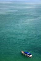 Lonely boat in the middle of the sea at Moo Koh Ang Thong National Marine Park, Thailand. Top or view of speedboat parked on ocean with above copy space. Transportation, trip and Beautiful of nature. photo