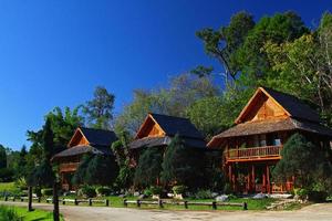 Thee wooden house with green tree and clear blue sky background at north of Thailand. Exterior design by use wood material to build and Beautiful in nature or Landmark for travel at Chiangmai. photo