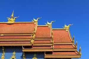 The beautiful roof of Wat Rong Sua Ten temple with clear blue sky background at Chiang Rai, Thailand. Buddhist, Landmark for travel, Exterior art design and Ancient place with copy space. photo