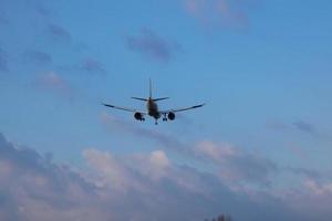 Commercial aircraft overflying the sky and arriving at airport photo