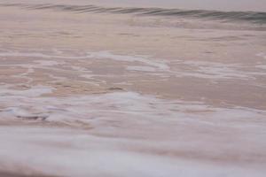 burbujas en dorado playa con Oceano agua en el Mañana a Tailandia playas foto