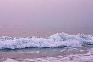 burbujas en dorado playa con Oceano agua en el Mañana a Tailandia playas foto