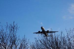 Commercial aircraft overflying the sky and arriving at airport photo