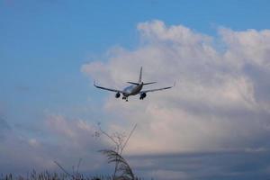 Commercial aircraft overflying the sky and arriving at airport photo