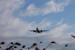 Commercial aircraft overflying the sky and arriving at airport photo