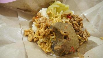 Nasi kucing special, cat rice special with opor hati sapi on a paper wrap photo