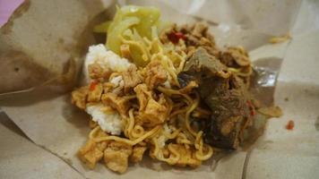 Nasi kucing special, cat rice special with opor hati sapi on a paper wrap photo