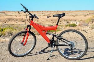 Red bicycle in the desert photo