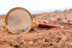 Magnifying glass in the dirt photo