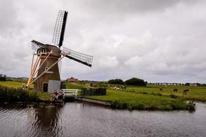 Traditional windmill under grey sky photo