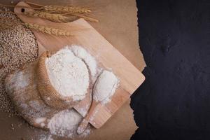 wheat flour in sacks With wheat ears on the table, black background. photo