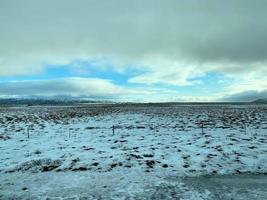 Icelandic winter landscape with snow covered hills and blue cloudy sky photo