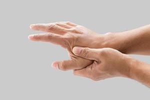 A man grab hand palm because the hand palm was injured. Hand pain. On a gray background. photo