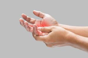 Pain in the palm of hand caused by bruising or injuring, Isolated on a gray wall background. photo