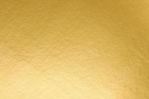 A gold paper that is textured and has a light shining on it. golden paper texture, photo