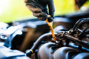 oil dipstick, lubrication In the hands of black rubber gloves,  Do-it-yourself car inspection, selective focus, soft focus. photo