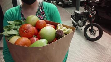 mujer que lleva un paquete de frutas y vegetales espalda hogar video