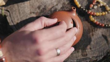 man's hand closes the lid of a clay teapot video